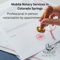 Hand applying a stamp to a document with text about mobile notary services in Colorado Springs.